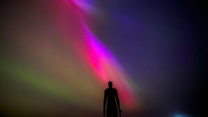 The aurora borealis, also known as the northern lights, glow on the horizon at Another Place by Anthony Gormley, Crosby Beach, Liverpool , Merseyside . Picture date: Friday May 10, 2024. PA Photo. See PA story WEATHER Aurora. Photo credit should read: Peter Byrne/PA Wire