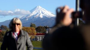 People take pictures with Mount Taranaki in the background. Pic: AP